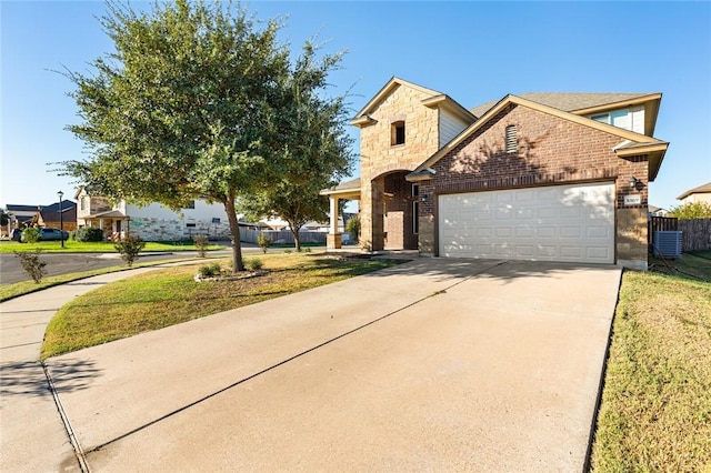 view of front of home featuring a garage, central air condition unit, and a front yard