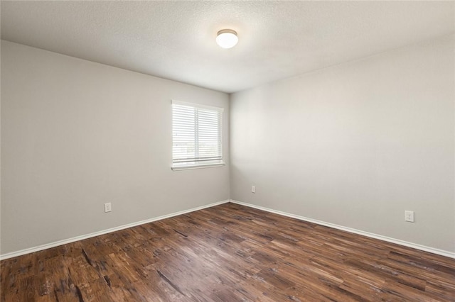 empty room featuring a textured ceiling and dark wood-type flooring