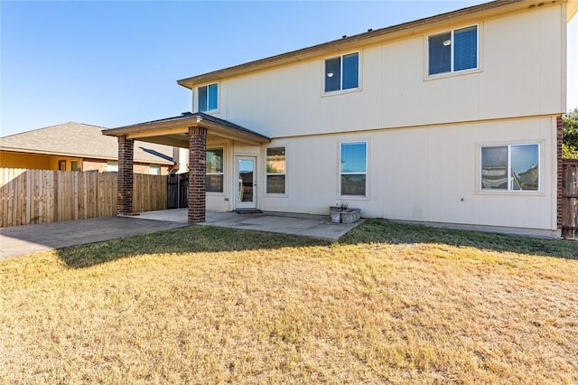 back of house with a patio area and a yard