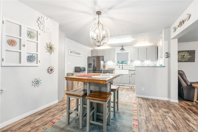 dining area featuring hardwood / wood-style flooring, sink, and a chandelier