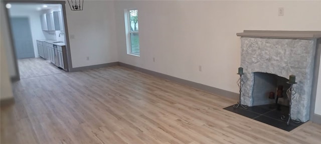 unfurnished living room featuring light wood-type flooring and sink