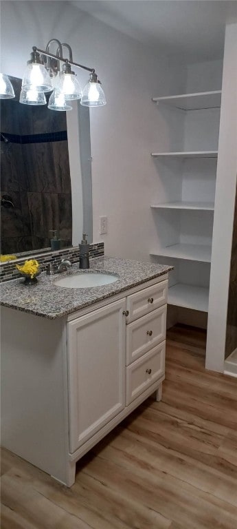 interior space with a shower, vanity, and hardwood / wood-style flooring