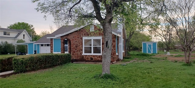 property exterior at dusk featuring a yard and a storage shed