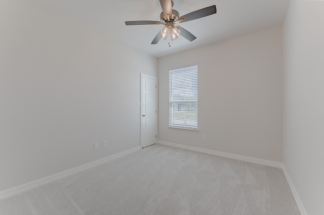 empty room featuring ceiling fan and light carpet