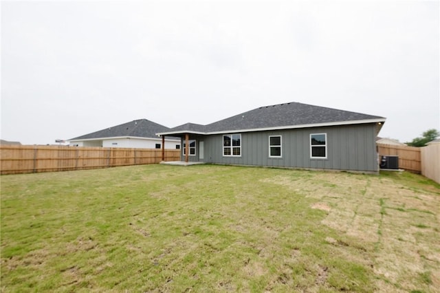 back of house featuring a lawn and cooling unit