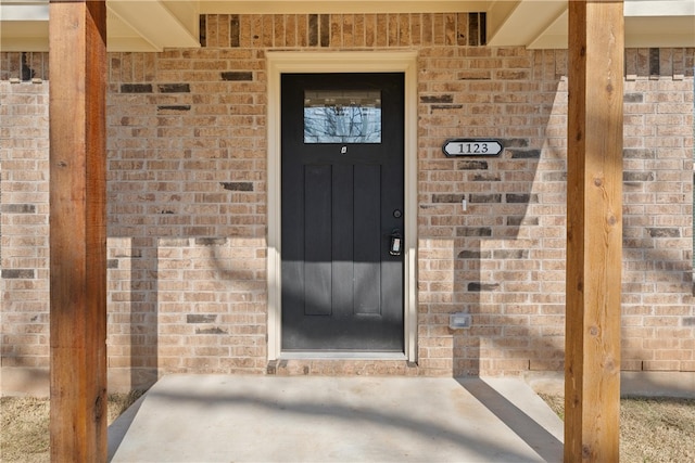 doorway to property featuring brick siding