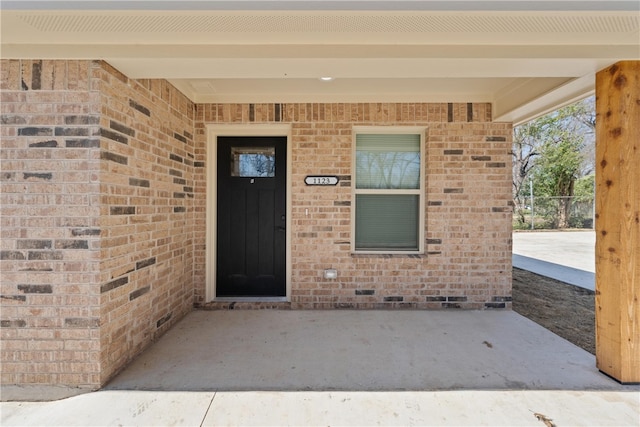 doorway to property with brick siding