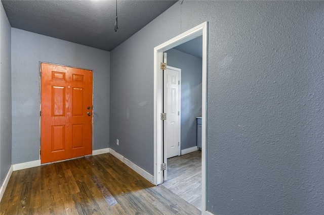 foyer with a textured ceiling and dark hardwood / wood-style floors