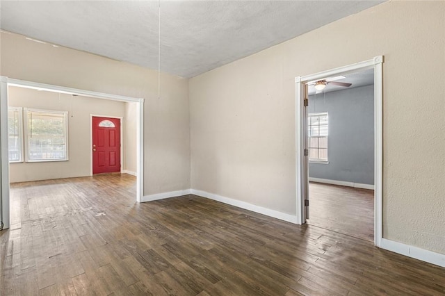 unfurnished room with dark hardwood / wood-style floors, ceiling fan, plenty of natural light, and a textured ceiling