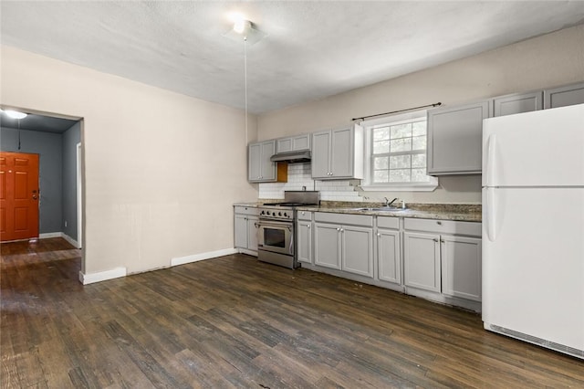 kitchen featuring gray cabinetry, dark wood-type flooring, white refrigerator, decorative backsplash, and high end stove