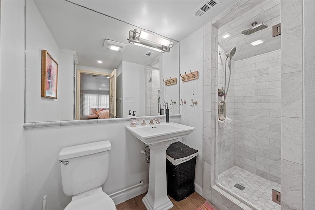 bathroom with hardwood / wood-style flooring, toilet, and an enclosed shower