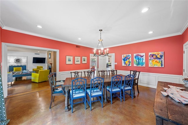 dining area featuring concrete flooring, a notable chandelier, and ornamental molding