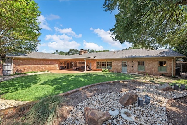 back of property with a yard and a patio area