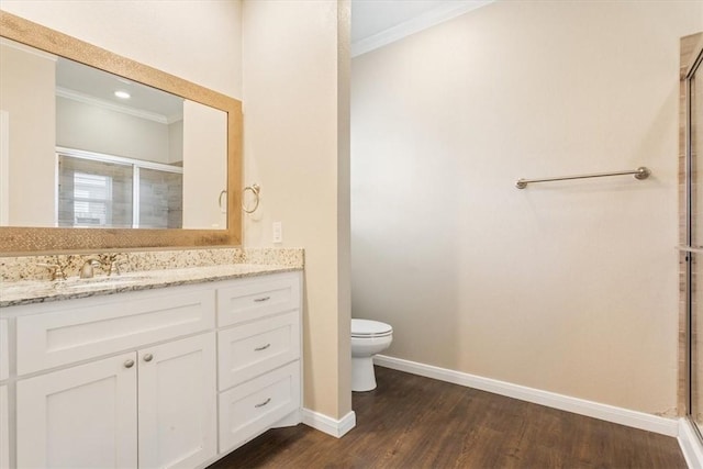 bathroom with wood-type flooring, vanity, toilet, and a shower with shower door