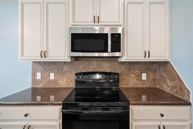 kitchen featuring backsplash, dark stone countertops, white cabinetry, and black electric range oven