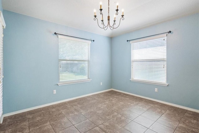 empty room with tile patterned flooring and an inviting chandelier