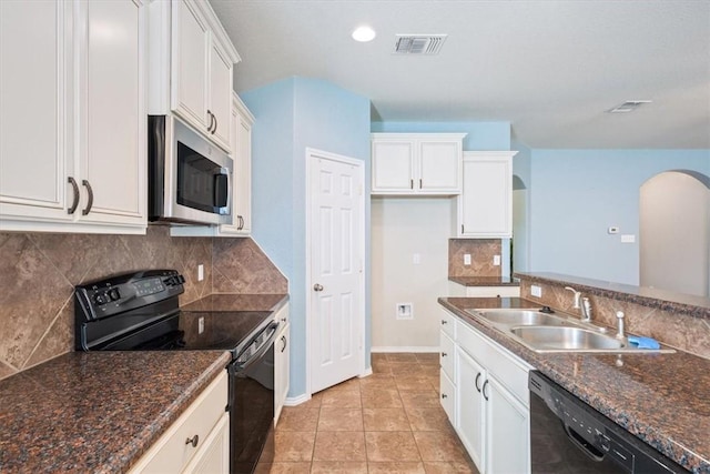 kitchen with dark stone countertops, sink, white cabinets, and black appliances