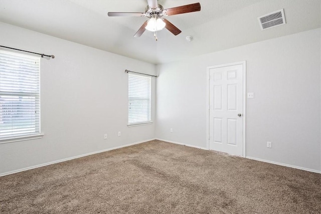 unfurnished room with ceiling fan and carpet