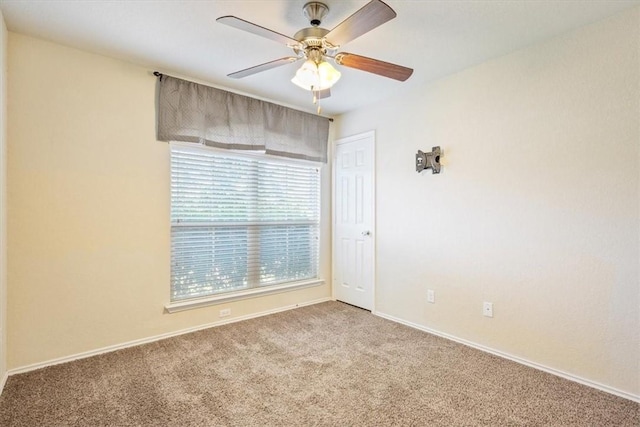 carpeted spare room featuring ceiling fan