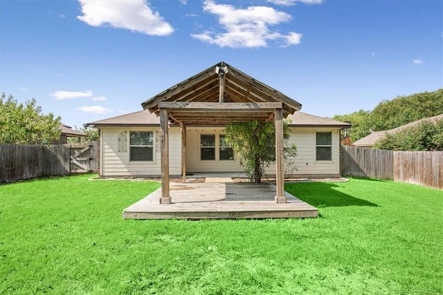 back of property with a deck and a lawn