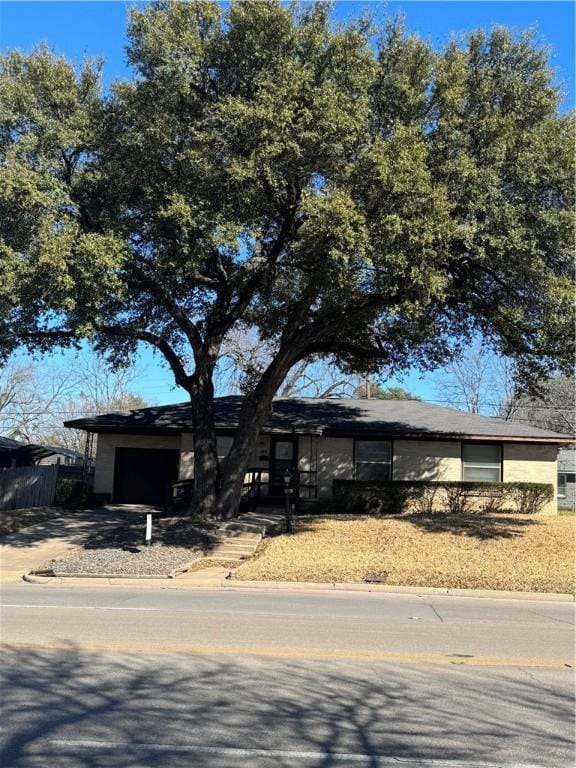 view of front of property with a garage, fence, and concrete driveway