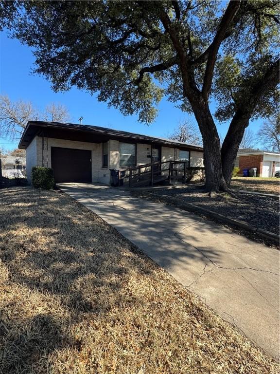 ranch-style home featuring a garage and driveway