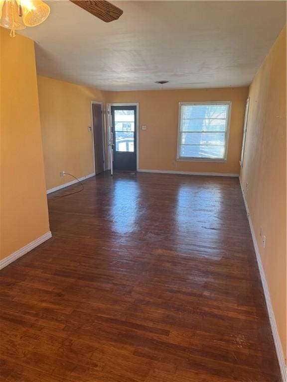 spare room with ceiling fan, wood finished floors, and baseboards