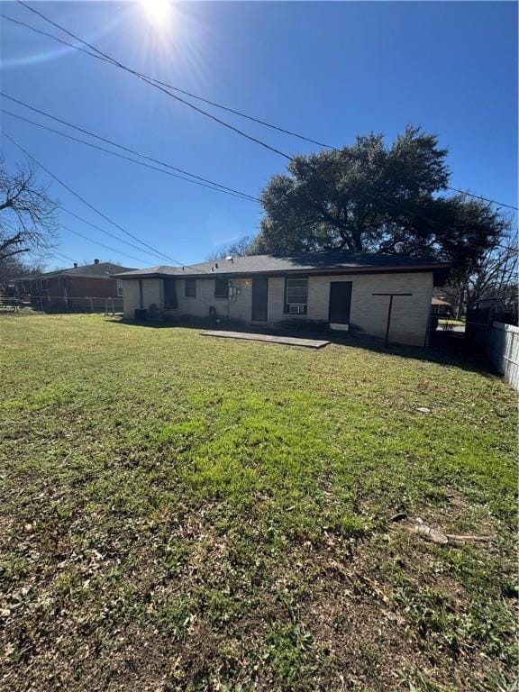 back of property with a yard and fence