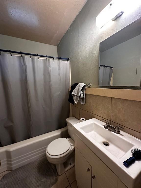 full bathroom featuring vanity, tile patterned flooring, toilet, tile walls, and tasteful backsplash