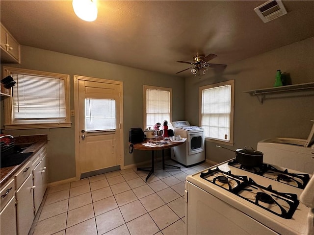 kitchen with ceiling fan, sink, light tile patterned floors, and white gas range oven