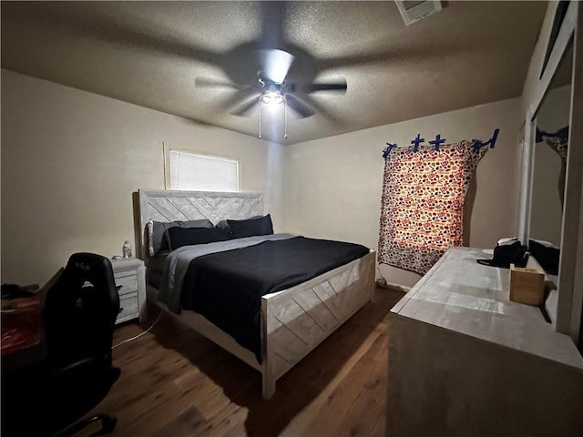 bedroom featuring a textured ceiling, dark hardwood / wood-style flooring, and ceiling fan