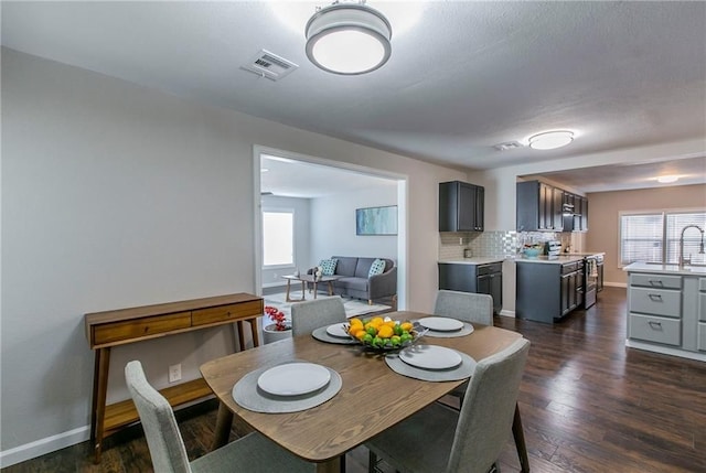 dining room with dark hardwood / wood-style flooring and sink