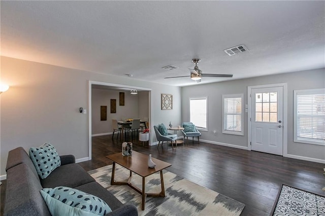 living room featuring ceiling fan and dark hardwood / wood-style flooring