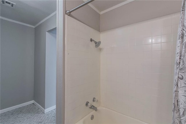 bathroom with crown molding and shower / tub combo