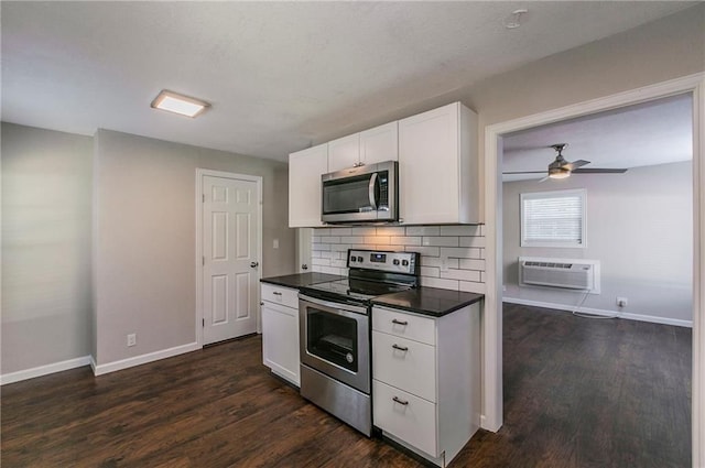 kitchen featuring white cabinets, an AC wall unit, dark wood-type flooring, and appliances with stainless steel finishes