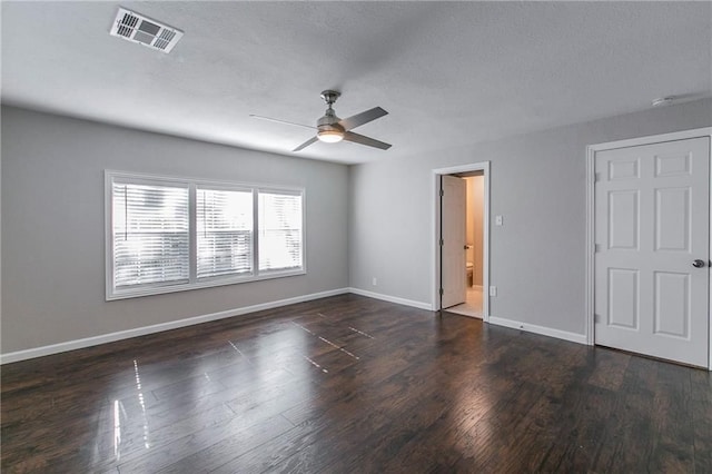 unfurnished bedroom with dark hardwood / wood-style floors, ceiling fan, a textured ceiling, and connected bathroom