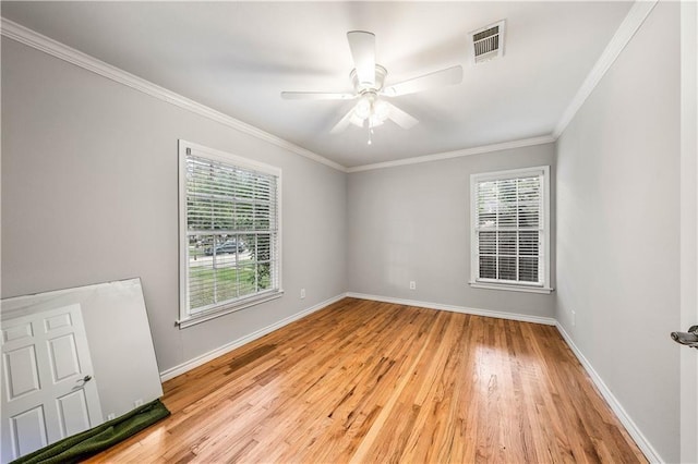 spare room featuring light hardwood / wood-style flooring, a healthy amount of sunlight, and ornamental molding