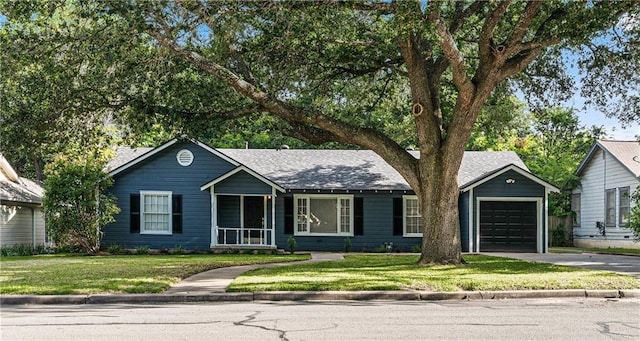 single story home with a porch, a garage, and a front lawn