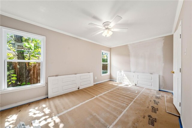 interior space featuring ceiling fan, ornamental molding, and a wealth of natural light