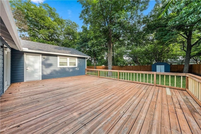 deck featuring a storage unit and a yard