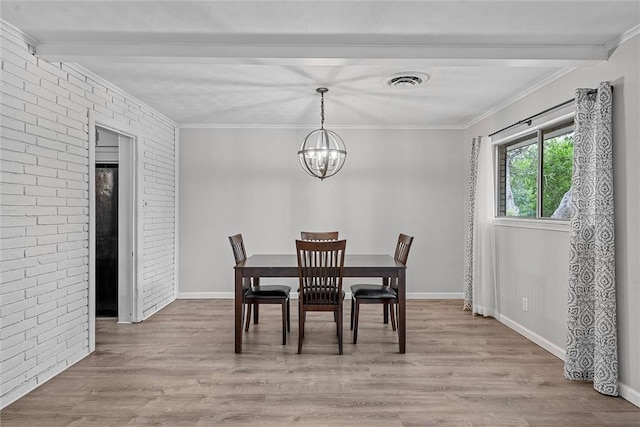 dining room with beam ceiling, light wood-type flooring, crown molding, and brick wall