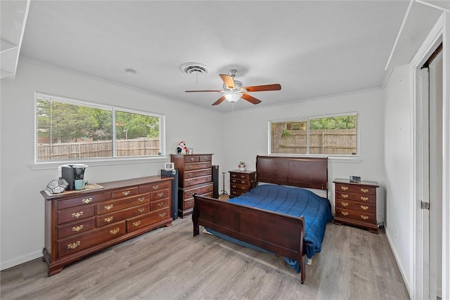 bedroom with light hardwood / wood-style floors, ceiling fan, and crown molding