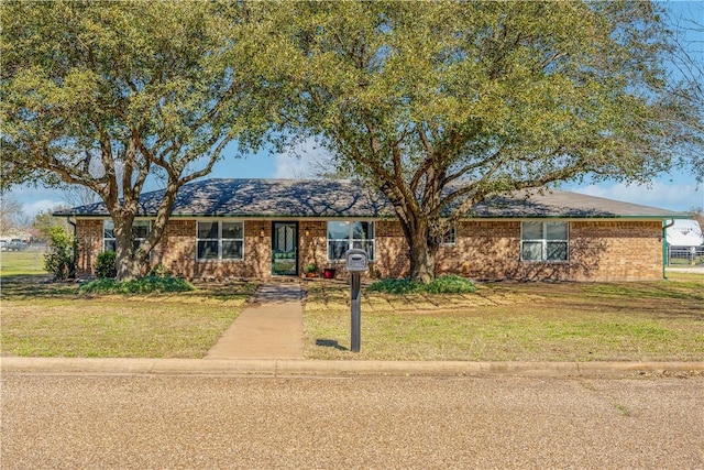 ranch-style home featuring brick siding and a front yard