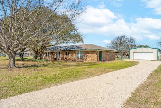 ranch-style home with a front yard, an outbuilding, brick siding, and a detached garage