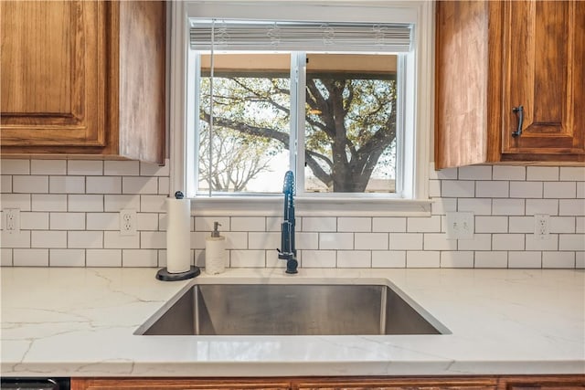 kitchen featuring a sink, a healthy amount of sunlight, and brown cabinetry