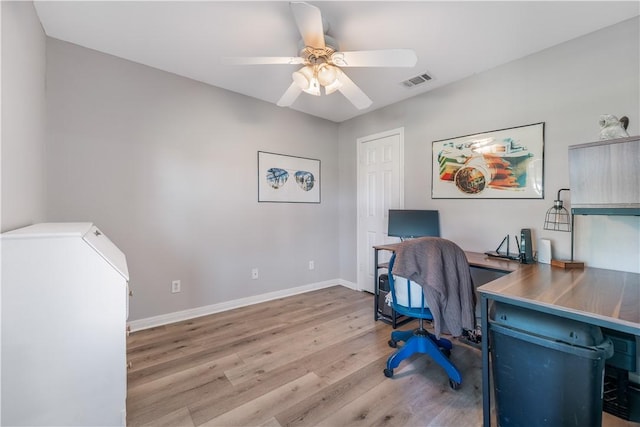 office area featuring light wood finished floors, visible vents, baseboards, and a ceiling fan