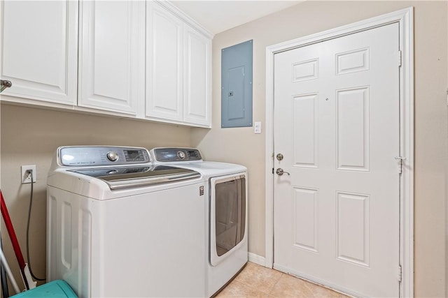 washroom with baseboards, washer and clothes dryer, light tile patterned floors, electric panel, and cabinet space