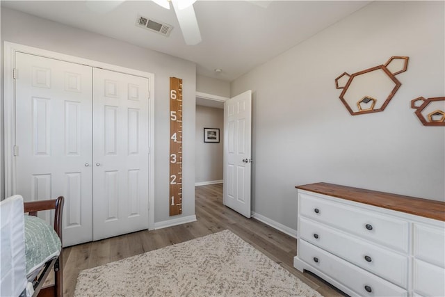 bedroom featuring visible vents, baseboards, a closet, and wood finished floors