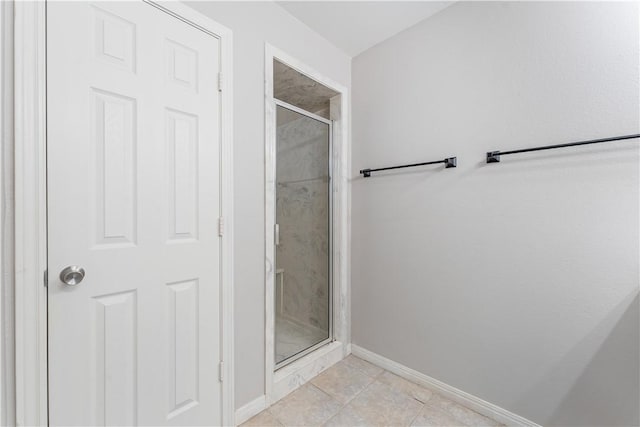 full bathroom with tile patterned floors, a shower stall, and baseboards