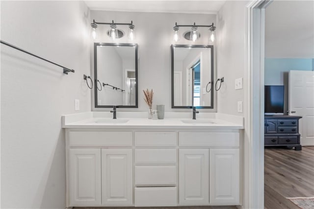 bathroom featuring a sink, wood finished floors, and double vanity